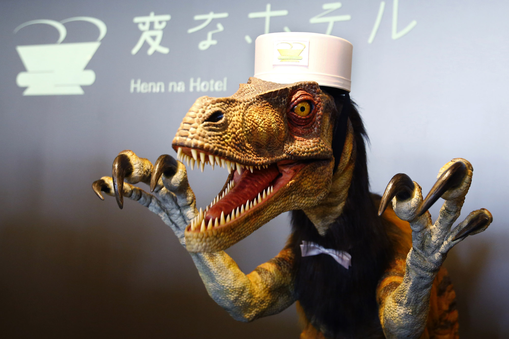 A receptionist dinosaur robot performs at the new robot hotel, aptly called Henn na Hotel or Weird Hotel, in Sasebo, southwestern Japan, Wednesday, July 15, 2015. From the receptionist that does the check-in and check-out to the porter thats a stand-on-wheels taking luggage up to the room, the hotel, that is run as part of Huis Ten Bosch amusement park, is manned almost totally by robots to save labor costs. (AP Photo/Shizuo Kambayashi)